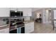 Modern kitchen featuring stainless steel appliances, white cabinets and drawers, with stylish tile backsplash at 8225 Drew St, Englewood, FL 34224
