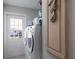 Laundry room with modern appliances and a door that leads to the outside at 8225 Drew St, Englewood, FL 34224