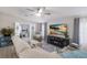 Bright living room features ceiling fan, modern entertainment center with fireplace, and view of office at 8225 Drew St, Englewood, FL 34224
