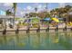 Waterfront dining at Beachcomber Bar featuring outdoor seating and sunny blue and yellow umbrellas at 8225 Drew St, Englewood, FL 34224