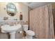 Bathroom with pedestal sink, tiled walls, and a shower with patterned curtain at 8280 Ibis St, Sarasota, FL 34241
