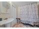 Bathroom showcasing a pedestal sink, a shower with a curtain, and neutral wall colors at 8280 Ibis St, Sarasota, FL 34241