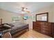 Comfortable bedroom with a queen size bed, ceiling fan, dresser, and natural light at 8280 Ibis St, Sarasota, FL 34241