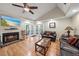 Cozy living room with fireplace, ceiling fan, wood floors, and access to the outdoors through double doors at 8280 Ibis St, Sarasota, FL 34241