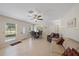 Bright living room with neutral colors, large window, tile floors, ceiling fan, and comfortable sofa at 8280 Ibis St, Sarasota, FL 34241