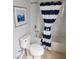 Bathroom with a striped shower curtain, white tile, and neutral-toned flooring at 9011 Hammock Edge Pl, Bradenton, FL 34212