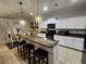 Bright kitchen with white cabinets, dark countertops, pendant lights, and barstool seating at 9011 Hammock Edge Pl, Bradenton, FL 34212