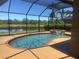 Beautiful backyard with a screened pool and spa overlooking a tranquil pond at 9011 Hammock Edge Pl, Bradenton, FL 34212