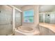 Well-lit bathroom including glass walk-in shower, jacuzzi tub and ample vanity lighting at 9238 13Th Avenue Nw Cir, Bradenton, FL 34209