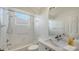 Bright bathroom featuring white tiled walls, a shower-tub combo and a vanity with white countertop at 9238 13Th Avenue Nw Cir, Bradenton, FL 34209