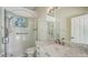 Bright bathroom with tiled shower, white marble-topped vanity, framed mirror, and modern fixtures at 9238 13Th Avenue Nw Cir, Bradenton, FL 34209