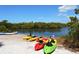 Colorful kayaks on a sandy beach beside calm waters, promising an adventurous and scenic paddling experience at 9238 13Th Avenue Nw Cir, Bradenton, FL 34209