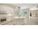 Bright white kitchen with marble counters, tiled floor and stainless appliances at 9238 13Th Avenue Nw Cir, Bradenton, FL 34209