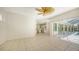 Living room with custom built-ins, ceiling fan and sliding glass doors to the kitchen at 9238 13Th Avenue Nw Cir, Bradenton, FL 34209