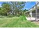 Expansive backyard lawn area with mature trees and landscaping providing a serene and private outdoor space at 8711 Palmer Park Cir, Sarasota, FL 34238