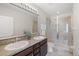 Bathroom featuring double sinks, granite counters, and a glass-enclosed shower at 8711 Palmer Park Cir, Sarasota, FL 34238