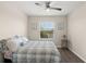 Bedroom features a ceiling fan, wood look floors, and a window view of palm trees at 8711 Palmer Park Cir, Sarasota, FL 34238