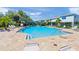 Refreshing community pool surrounded by comfortable seating and lush green trees at 8711 Palmer Park Cir, Sarasota, FL 34238