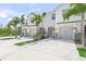 Charming townhomes with well-manicured lawns, decorative stone, and palm trees create a welcoming curb appeal at 8711 Palmer Park Cir, Sarasota, FL 34238