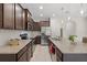 Modern kitchen featuring granite countertops, stainless steel appliances, and dark wood cabinetry at 8711 Palmer Park Cir, Sarasota, FL 34238