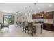 Open-concept kitchen and living area with a breakfast bar, modern lighting, and sliding glass doors to the patio at 8711 Palmer Park Cir, Sarasota, FL 34238