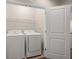 Clean laundry room with white appliances and a door leading to another room at 8711 Palmer Park Cir, Sarasota, FL 34238
