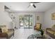 Inviting living room with tiled flooring, sliding glass doors to the outdoor area, and comfortable wicker seating at 8711 Palmer Park Cir, Sarasota, FL 34238