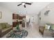 Bright, open living area with a modern kitchen island, wicker furniture, and neutral tile flooring at 8711 Palmer Park Cir, Sarasota, FL 34238