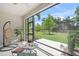 The screened lanai area includes seating and is the perfect spot to relax and enjoy the view of the lovely green lawn at 8711 Palmer Park Cir, Sarasota, FL 34238