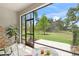 The screened lanai area includes seating and is the perfect spot to relax and enjoy the view of the lovely green lawn at 8711 Palmer Park Cir, Sarasota, FL 34238