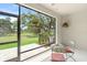 A screened lanai overlooking a lush green lawn features a table and chairs perfect for enjoying the peaceful outdoor view at 8711 Palmer Park Cir, Sarasota, FL 34238