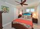 Cozy bedroom featuring a unique tropical decor, ceiling fan, and brightly colored bedding and decorative pillows at 10016 Spoonbill E Rd, Bradenton, FL 34209