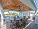 Outdoor patio features a dining area with seating, a fan, and waterfront views, ideal for alfresco dining at 10016 Spoonbill E Rd, Bradenton, FL 34209