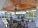 Charming outdoor dining area under a wooden pavilion with serene canal views, perfect for gatherings and relaxation at 10016 Spoonbill E Rd, Bradenton, FL 34209