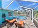 Inviting pool area with hot tub, sun loungers, and canal views, creating an ideal outdoor oasis for relaxation at 10016 Spoonbill E Rd, Bradenton, FL 34209