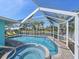 Relaxing pool and hot tub area with waterfront views, complete with comfortable lounge chairs and lush palm trees at 10016 Spoonbill E Rd, Bradenton, FL 34209