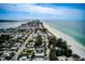 An aerial view displays a coastal community with homes lining a pristine beach and turquoise ocean waters at 104 29Th St # 3, Holmes Beach, FL 34217