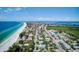 An aerial view displays a coastal community with homes lining a pristine beach and turquoise ocean waters at 104 29Th St # 3, Holmes Beach, FL 34217
