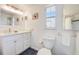 Clean bathroom with white vanity, a toilet, decorative mirror, and a shower with tiled walls at 104 29Th St # 3, Holmes Beach, FL 34217