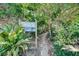 A sandy path leads to the beach, framed by lush greenery and a prominent 'Beach Access' sign at 104 29Th St # 3, Holmes Beach, FL 34217