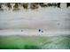Overhead shot of a beach featuring beach umbrellas and a coastline of emerald green water meeting a sandy shoreline at 104 29Th St # 3, Holmes Beach, FL 34217