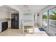 Bright dining area with a white table, adjacent kitchen, and sliding glass doors leading to a deck at 104 29Th St # 3, Holmes Beach, FL 34217