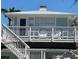 Inviting two-story beach house featuring a cozy balcony with relaxing chairs and ample natural light at 104 29Th St # 3, Holmes Beach, FL 34217