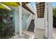 Exterior stairs lead up to a deck, painted in soothing blues and whites, complemented by lush greenery at 104 29Th St # 3, Holmes Beach, FL 34217