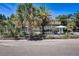 Charming beach house with lush landscaping, shaded seating area, and inviting curb appeal at 104 29Th St # 3, Holmes Beach, FL 34217
