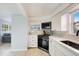 Modern kitchen featuring sleek black appliances, quartz countertops, and ample natural light at 104 29Th St # 3, Holmes Beach, FL 34217