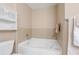 Bright bathroom featuring a tile surround tub and decorative storage cabinet at 1064 N Tamiami Trl # 1425, Sarasota, FL 34236