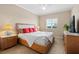 Bright bedroom featuring a ceiling fan, neutral walls, and a comfortable queen-sized bed with red pillows at 1064 N Tamiami Trl # 1425, Sarasota, FL 34236