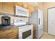 Modern kitchen featuring updated appliances, wood cabinets, and granite countertops at 1064 N Tamiami Trl # 1425, Sarasota, FL 34236