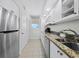 Bright kitchen with stainless steel appliances, granite countertops, and white cabinetry at 1095 Gulf Of Mexico Dr # 503, Longboat Key, FL 34228